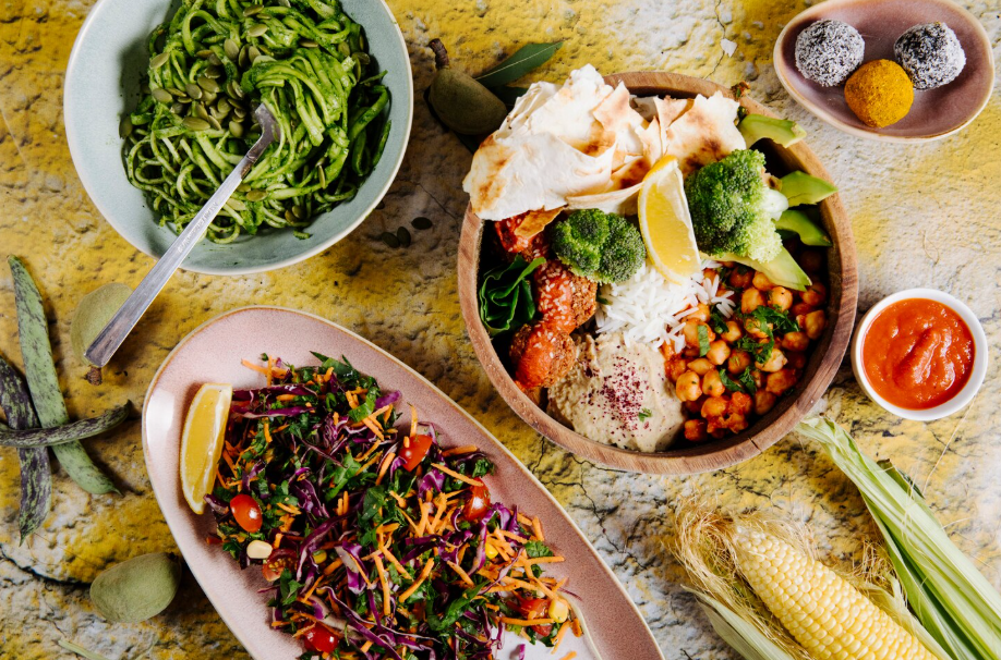 Overhead view of vibrant plant-based comfort food, including a grain bowl with chickpeas and veggies.